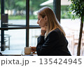 Thoughtful businesswoman thinking on project and financial information while having coffee in cafe. 135424945