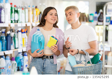 Couple man and woman choosing household chemicals in store 135425295