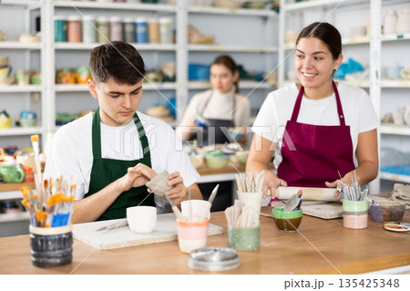 Young woman and young man making pottery Young woman and young man making pottery 135425348
