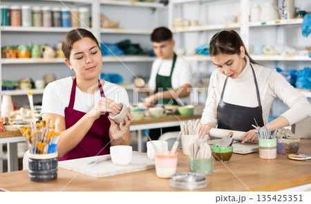 Concentrated young women making handmade cups 135425351
