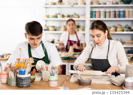 Young woman and young man making pottery Young woman and young man making pottery 135425394