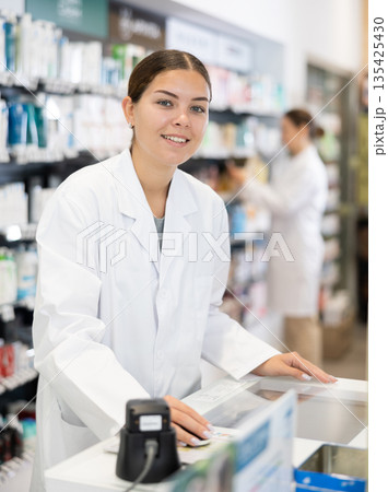 Portrait of female pharmacist at cash register in interior of pharmacy 135425430