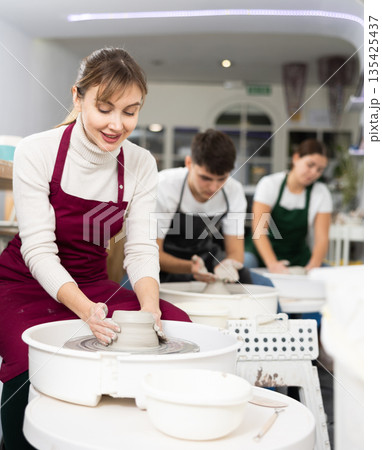 Young woman sculpting product on potter's wheel 135425437