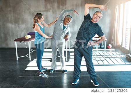 Stretching, physiotherapy and old couple with personal trainer for fitness, wellness and helping. Health, workout and retirement with senior patient and physiotherapist in class for warm up training Stretching, physiotherapy and old couple with personal trainer for fitness, wellness and helping. Health, workout and retirement with senior patient and physiotherapist in class for warm up training 135425801