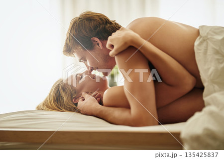 Love, kiss and couple in bedroom, hug and happiness with passion, romance and loving together. Romantic, man or woman with care, bed or embrace with joy, intimate or bonding with a happy relationship 135425837
