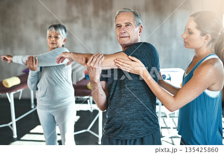Stretching, physiotherapy and old man with personal trainer for fitness, wellness or rehabilitation. Health, workout or retirement with senior patient and physiotherapist in gym for warm up training Stretching, physiotherapy and old man with personal trainer for fitness, wellness or rehabilitation. Health, workout or retirement with senior patient and physiotherapist in gym for warm up training 135425860