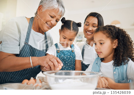 Grandmother teaching, mom or kids baking in kitchen as a happy family with young girl learning a recipe. Mixing cake, parent or grandma smiling or helping children to bake with eggs for development 135426039