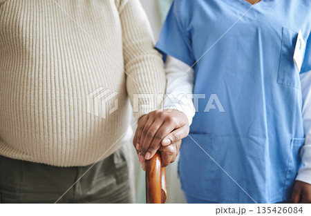 Nurse, holding hands and senior patient with a cane for support, healthcare and kindness at nursing home. Person, caregiver and woman together for trust, elderly care and help in retirement Nurse, holding hands and senior patient with a cane for support, healthcare and kindness at nursing home. Person, caregiver and woman together for trust, elderly care and help in retirement 135426084