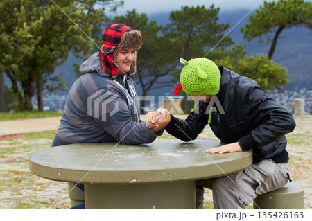 Arm wrestling, friends and winning outdoor at table for sports, challenge and exercise. Strong, conflict and men holding hands for competition, power and muscle match, training or workout in park. Arm wrestling, friends and winning outdoor at table for sports, challenge and exercise. Strong, conflict and men holding hands for competition, power and muscle match, training or workout in park. 135426163