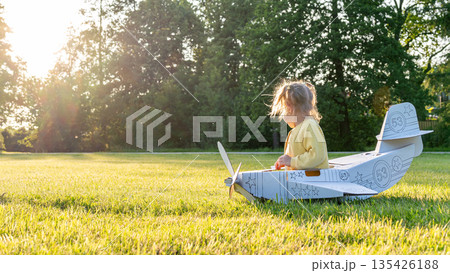 Pretend play child. Girl aviation pilot toy. Summer fun outdoor cardboard. 135426188