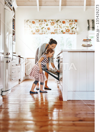 Food, mother with her child baking and in the kitchen of their home with a lens flare. Happy family or bonding time, bake or cook and woman with girl at the oven prepare a meal for lunch together Food, mother with her child baking and in the kitchen of their home with a lens flare. Happy family or bonding time, bake or cook and woman with girl at the oven prepare a meal for lunch together 135426273