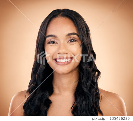 Portrait, hair and smile with a model woman in studio on a brown background for shampoo treatment. Beauty, salon and haircare with a happy young person looking confident about natural cosmetics 135426289