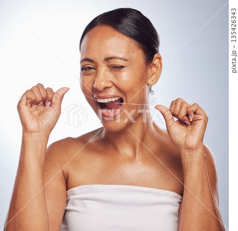 Dental, portrait or mature woman flossing teeth for beauty or wellness in studio on white background. Smile, self care or healthy senior model grooming or cleaning her tooth or mouth for hygiene Dental, portrait or mature woman flossing teeth for beauty or wellness in studio on white background. Smile, self care or healthy senior model grooming or cleaning her tooth or mouth for hygiene 135426343