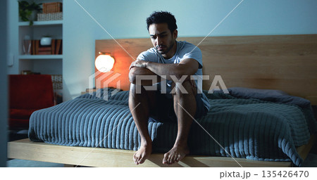 Night, lonely and man thinking with depression, mental health or insomnia from sad memories in bedroom. Late, contemplation or anxious person with grief, worry and sleepless from stress in apartment. Night, lonely and man thinking with depression, mental health or insomnia from sad memories in bedroom. Late, contemplation or anxious person with grief, worry and sleepless from stress in apartment. 135426470