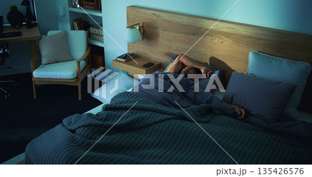 Sleeping, rest and man in bed in home on weekend with exhaustion, fatigue or burnout with dreaming. Relax, above and tired male person with nap in bedroom with blanket for comfort in apartment. Sleeping, rest and man in bed in home on weekend with exhaustion, fatigue or burnout with dreaming. Relax, above and tired male person with nap in bedroom with blanket for comfort in apartment. 135426576