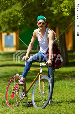 Bicycle, park and portrait of young man for travel, journey and carbon footprint, streetwear and cool fashion at university. Person or college student in sunglasses, bike transport and outdoor campus Bicycle, park and portrait of young man for travel, journey and carbon footprint, streetwear and cool fashion at university. Person or college student in sunglasses, bike transport and outdoor campus 135426715