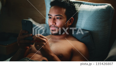 Night, man and typing in bed with phone for text message reply, social media and check dating site. Late, person and browsing with tech in apartment for online conversation, internet and mobile app. 135426807