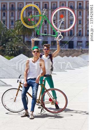 Bicycle, men and friends in a city street with freedom, holiday or vacation, pose and attitude on urban background. Bike, cyclist and people outdoors for cycling, fitness and having fun in London 135426961