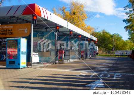Car wash station with bright signage in autumn setting during sunny day 135428548