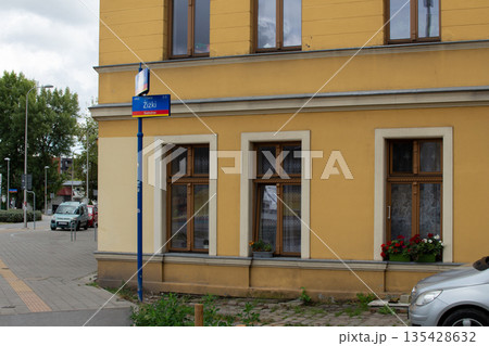 City street corner in a quiet neighborhood with a bus stop and flower boxes  135428632