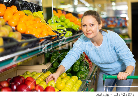 woman chooses apples in farm shop 135428875
