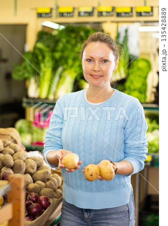 housewife in vegetable shop chooses high-quality potato housewife in vegetable shop chooses high-quality potato 135428889