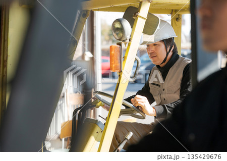 フォークリフトを操作する作業員 135429676