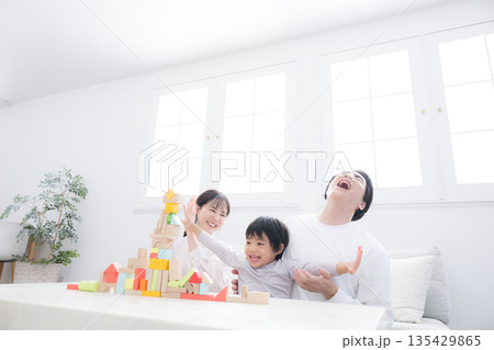 子どもと一緒にリビングで楽しく遊ぶ両親 休日の子育てイメージ 子育ては大変だ~ 子どもと一緒にリビングで楽しく遊ぶ両親 休日の子育てイメージ 子育ては大変だ~ 135429865