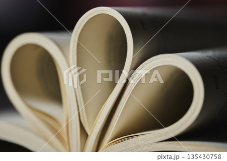 Extreme close up of book pages forming a rhythmic curved pattern 135430758