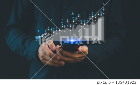 Businessman analyzing e-commerce growth graph on smartphone, showing rising sales performance, digital marketing success, and online business strategy with data analytics concept for financial growth. Businessman analyzing e-commerce growth graph on smartphone, showing rising sales performance, digital marketing success, and online business strategy with data analytics concept for financial growth. 135431922