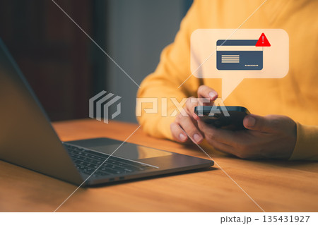 Credit card alert notification concept showing person holding smartphone with warning message, symbolizing online payment error, digital banking security risk, and financial fraud prevention. 135431927