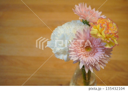 花瓶に生けた優しい色合いの花 ガーベラとカーネーションの静物 135432104