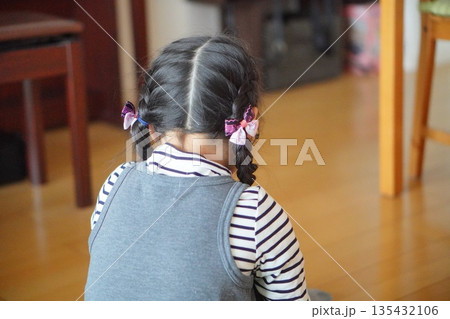 室内で座る三つ編みの女の子の後ろ姿 静かな日常のひとコマ 室内で座る三つ編みの女の子の後ろ姿 静かな日常のひとコマ 135432106