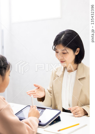 小学生に勉強を教える塾講師の女性 小学生に勉強を教える塾講師の女性 135432396
