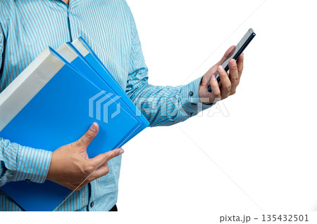 Close-up of Asian businessman holding blue folders in one hand and using smartphone with the other, representing multitasking, office work, document management, and digital communication efficiency Close-up of Asian businessman holding blue folders in one hand and using smartphone with the other, representing multitasking, office work, document management, and digital communication efficiency 135432501