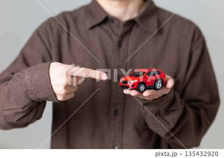 自動車の模型を指差すミドル男性 135432920