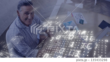 Man wearing plaid shirt typing at desk in office, with printed charts, binary code, copy space Man wearing plaid shirt typing at desk in office, with printed charts, binary code, copy space 135433298