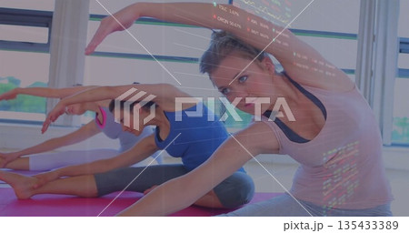 Stretching woman in sportswear reaching toward leg on yoga mat in yoga studio, copy space 135433389