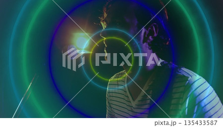Singing musician wearing V-neck shirt on stage, with mic, backlight and neon rings, copy space Singing musician wearing V-neck shirt on stage, with mic, backlight and neon rings, copy space 135433587