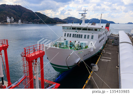 愛媛県　八幡浜港白フェリーの冬停泊 赤ローダー緑デッキ山景 135433985