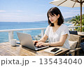 海が見えるテラスで作業をするリモートワーカー 135434040