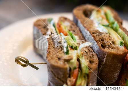 Beautiful photo showcasing nutritious multilayered bread creation in warm ambiance 135434244