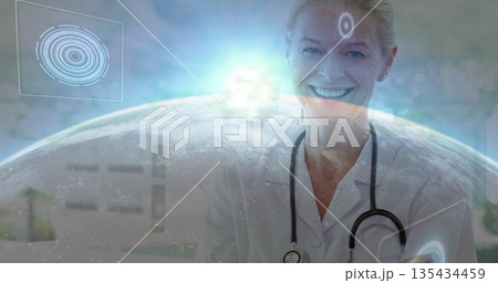 Smiling female doctor presenting interface in clinic, with stethoscope, tablet, globe, copy space Smiling female doctor presenting interface in clinic, with stethoscope, tablet, globe, copy space 135434459