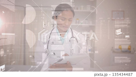 Reviewing digital charts female doctor using tablet in clinic, with stethoscope and medicine 135434487