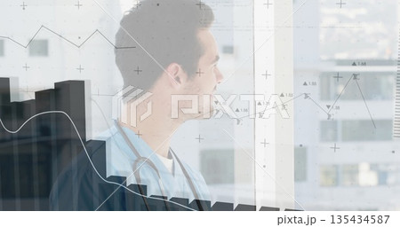 Medical worker wearing teal scrubs gazing out large clinic window, with stethoscope, data charts Medical worker wearing teal scrubs gazing out large clinic window, with stethoscope, data charts 135434587