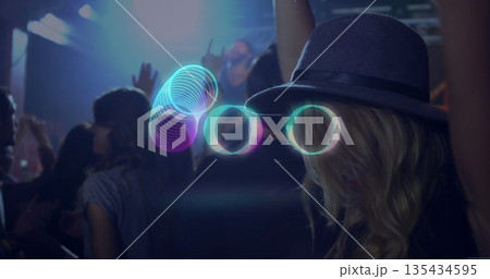 Interacting woman wearing grey fedora manipulating neon rings at concert venue, copy space Interacting woman wearing grey fedora manipulating neon rings at concert venue, copy space 135434595
