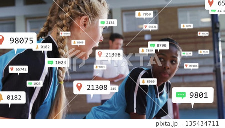 Leaning athletes wearing blue jerseys discussing strategy in school gym with analytics overlay Leaning athletes wearing blue jerseys discussing strategy in school gym with analytics overlay 135434711