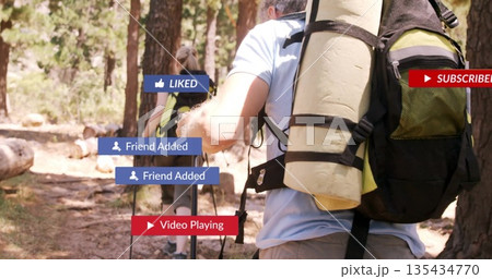 Couple wearing hiking gear trekking pine trail, with backpacks mats trekking poles media icons Couple wearing hiking gear trekking pine trail, with backpacks mats trekking poles media icons 135434770
