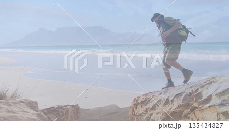 Surveying male hiker wearing bucket hat with backpack and hiking boots on coastal cliff, copy space Surveying male hiker wearing bucket hat with backpack and hiking boots on coastal cliff, copy space 135434827
