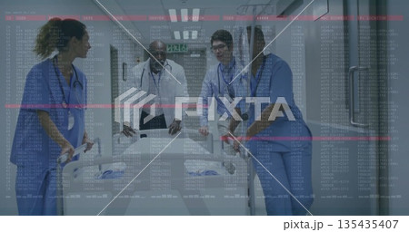 Medical staff pushing stretcher through hospital corridor, with stethoscopes and ID badges Medical staff pushing stretcher through hospital corridor, with stethoscopes and ID badges 135435407